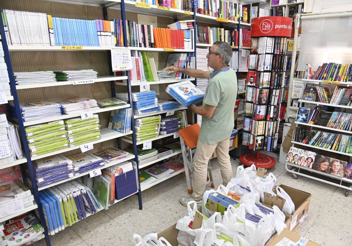 Un librero organizando libros de texto de cara al inicio del curso.