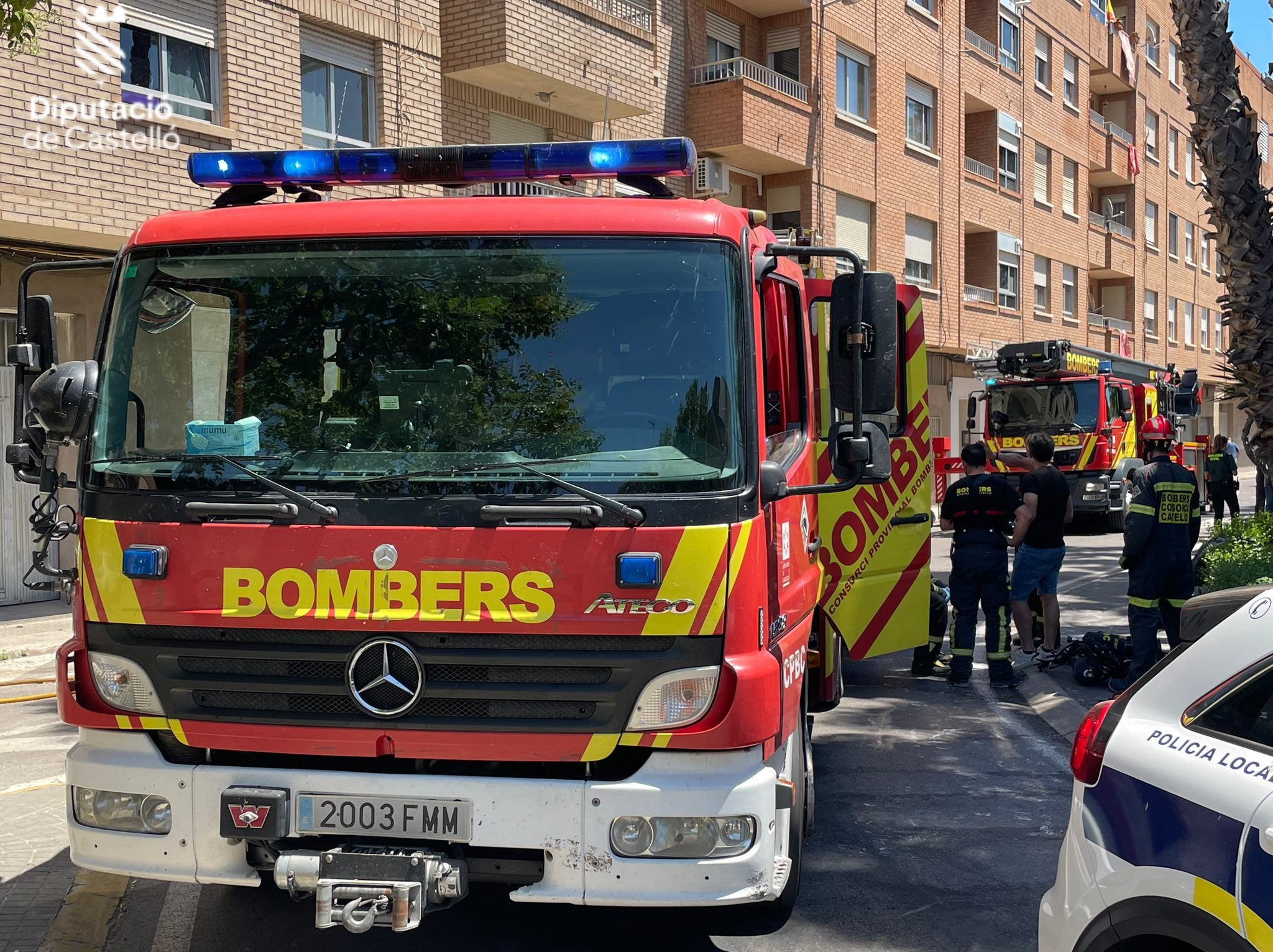 Arriba, los efectivos de bomberos desplazados en la zona. Abajo, el edifico incendiado.