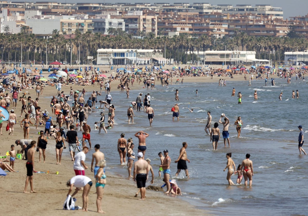 Imagen principal - Playa llena de bañistas, única zona de tumbonas en Marina Beach y almacén con hamacas.