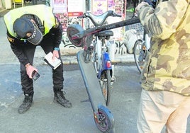 Un policía local inspecciona un patineta en una imagen de archivo.