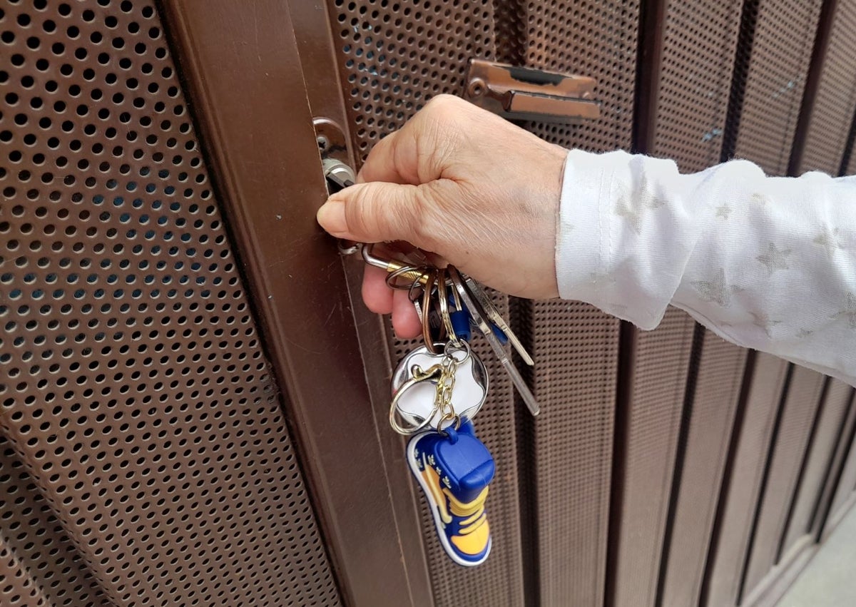 Imagen secundaria 1 - Un hombre camina el viernes junto al garaje donde se cometió el crimen. Abajo, el edificio y la cerradura que abrió Salva con las llaves que le dio Maje para poder acceder.
