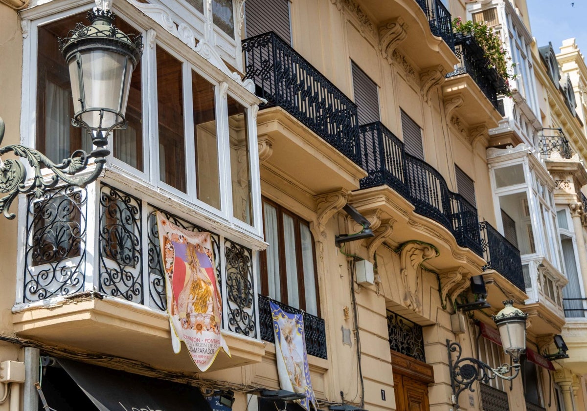 Imagen principal - Balcón con un tapiz de la Virgen; Elisa Peris, de Peris Roca, con su negocio y justo al lado un apartamento turístico, y Ana y Paula, de la librería Praxis, en la calle Avenallas.