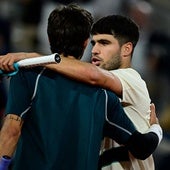 El español Carlos Alcaraz consuela al italiano Lorenzo Musetti tras su retirada por lesión al final de su partido