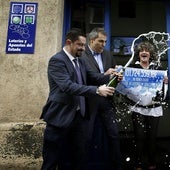 Propietarios de una administración de lotería celebran la entrega de un premio.