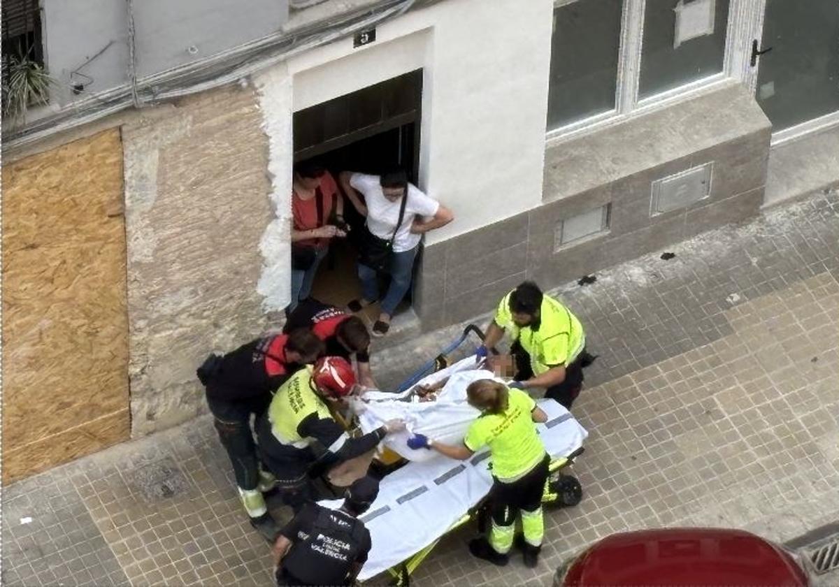 El hombre, entre bomberos, personal sanitario y policías, tras ser rescatado.