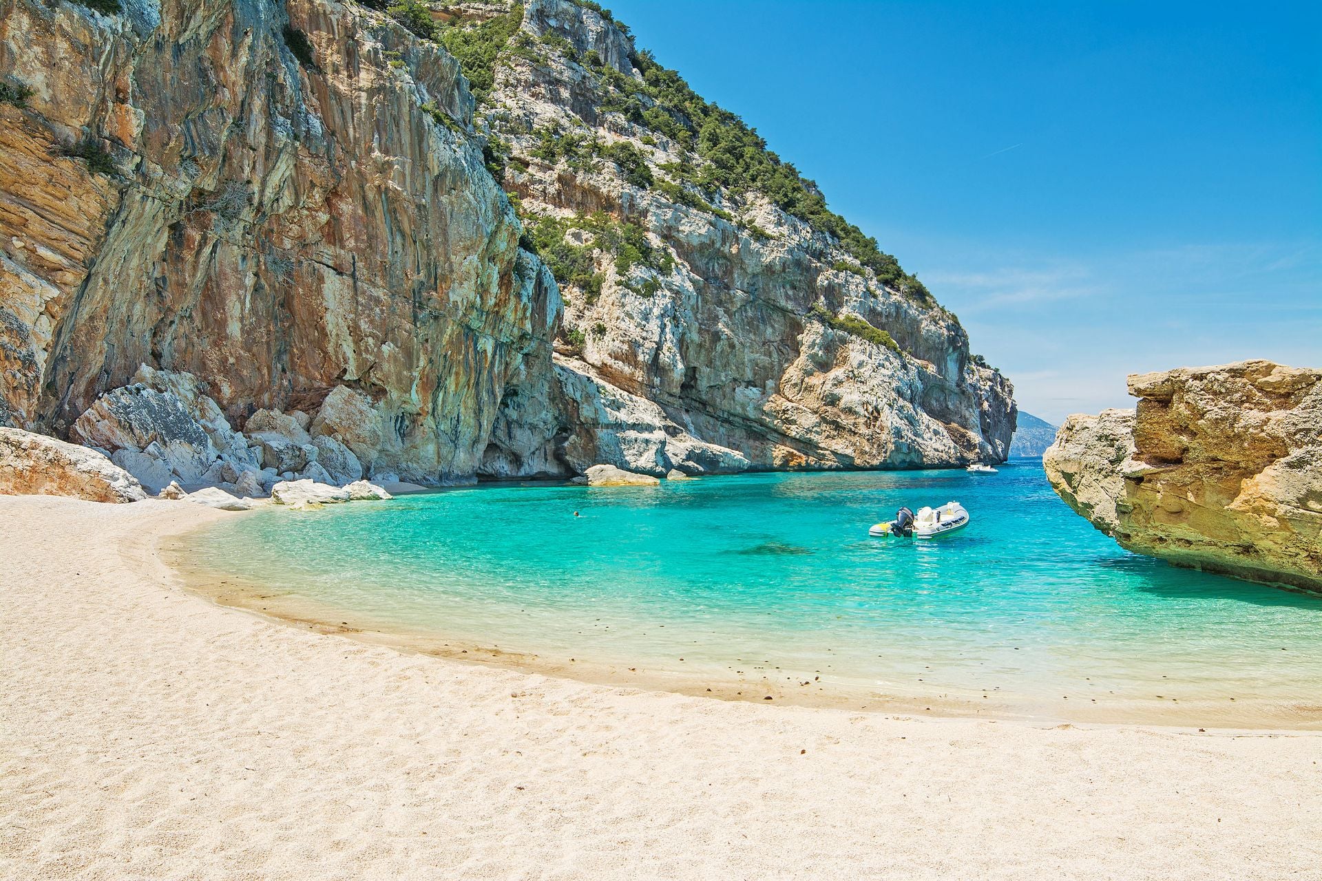 Cala Mariolu, Cerdeña (Italia), Los uruarios de Jetcost la describen como «perla del golfo de Orosei», además de que es «un rincón salvaje y virgen, una caleta íntima caracterizada por abundantes piedras blancas y rosas que se descubren después de un recorrido por la naturaleza selvática o un paseo en barco». También explican que «es conocida por 'is pùligi de nie (las pulgas de nieve)', unas piedras blancas y rosas, mezcladas con la arena, que la componen». «Su vista asombra por los tonos de infinito azul, verde esmeralda y celeste» y señalan que su fondo marino «merece una inmersión ya que es un hábitat de varias especies. También los delfines de vez en cuando se dejan ver en la costa». Por último, advierten que «el acceso es complicado y lo mejor es hacerlo por con barcos privados o con servicios para las calas que salen de los puertos de Arbatax, Cala Gonone y Santa Maria Navarrese».