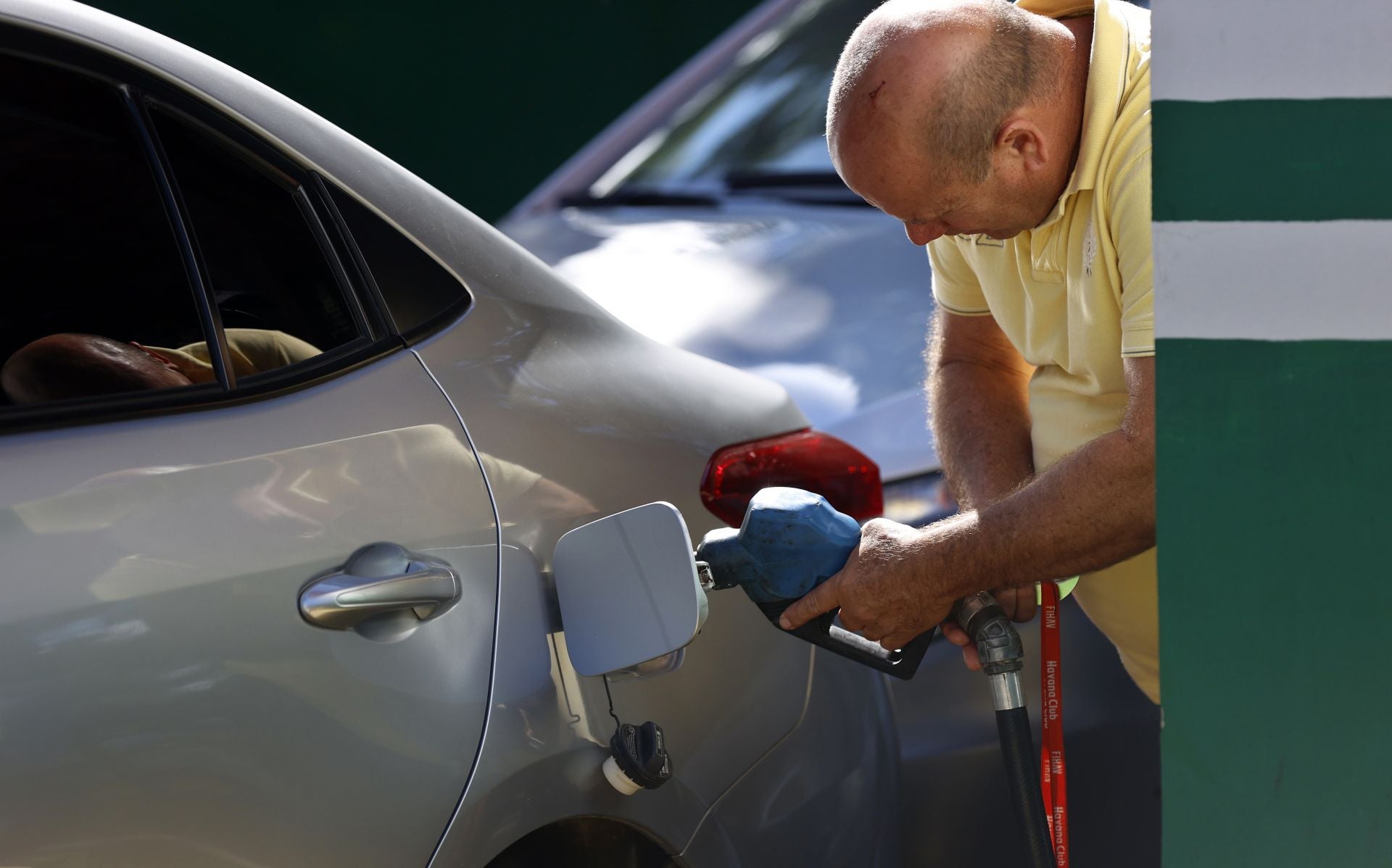 Una persona pone gasolina en su vehículo.