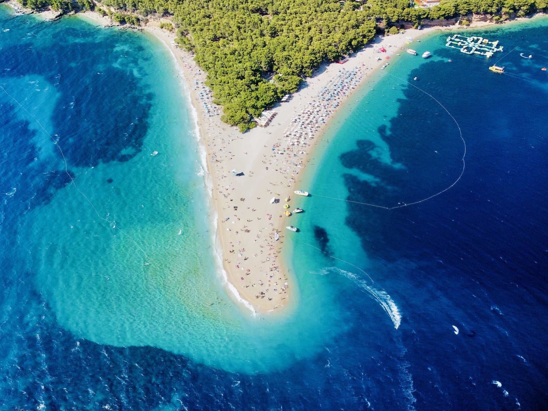Zlatni Rat, Isla de Brač (Croacia). La describen como una «singular playa en forma de punta de lanza que se extiende como un cuerno dorado en el mar de casi mil metros de largo, acaricia el mar cristalino y turquesa y su extremo cambia de forma en un juego entre el viento, las olas y las corrientes marinas». «Se la considera como una de las mejores playas de Europa y del mundo y es un símbolo del turismo croata y de la belleza natural», añaden. También cuentan que «hay un bosque centenario de pino mediterráneo justo al borde del agua, donde encontrar fácilmente una sombra para escapar del sol durante las horas más calurosas del día». Además, los expertos desvelan que su belleza y popularidad hacen que sea una playa bastante concurrida, pero existen otras calas a lo largo de la costa de Brac mucho más tranquilas. Zlatni Rat es una reserva natural protegida y un destino codiciado tanto para los practicantes de kitesurf como para los surfistas.