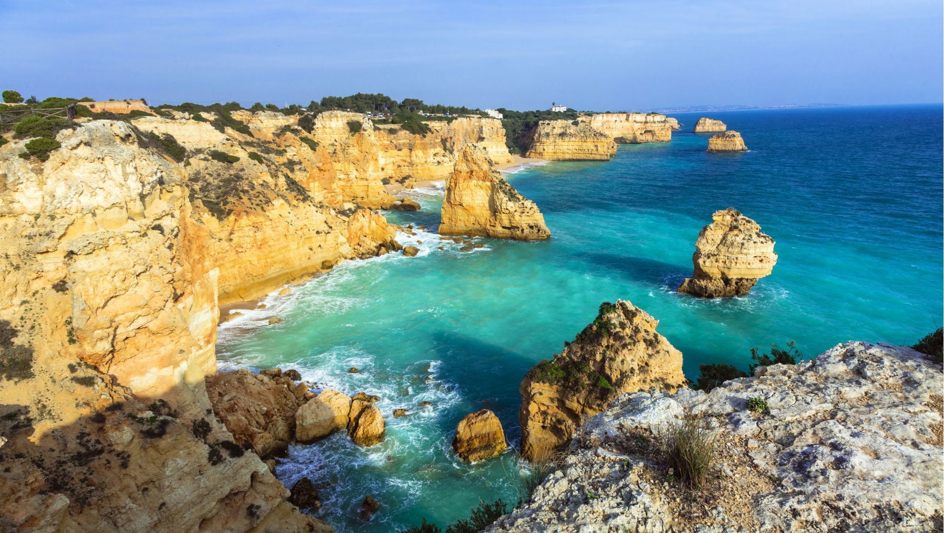 Praia da Marinha, Algarve (Portugal). A unos 60 kilómetros de Faro, hacia el oeste, se encuentra Praia da Marinha, «considerada la más bella del sur de Portugal y una de las 10 playas más bellas de Europa». Según explican desde Jetcost, «para disfrutarla, vale la pena madrugar y visitarla muy pronto por la mañana». Entre su belleza destaca «las formas caprichosas de los monolitos rocosos y la gama de colores que la inundan la convierten en una joya». Los expertos invitan a «dar un paseo, comer buen marisco, beber vinho blanco o verde y luego darse un baño», algo que describen como «un placer». «Existe la posibilidad de coger una barquita y descubrir grutas ocultas en ese tramo de la costa», terminan.