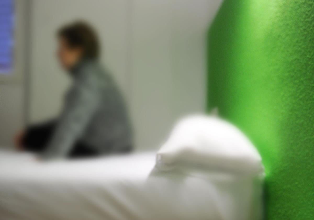 Una mujer, sentada en la cama, en una imagen de archivo.