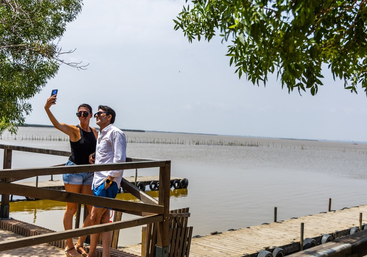 Una pareja se hace fotos al pie de la laguna