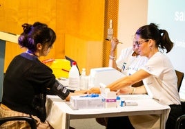 Una paciente, con dos de las sanitarias que participan en el cribado.