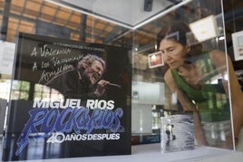 Una mujer mira el disco firmado por Miguel Ríos para la muestra.