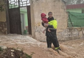 El jefe de la Policía Local de Cheste, Daniel Gallardo, sujeta en sus brazos al niño que rescató el 29-O