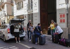 Turistas cargados de maletas, en una céntrica calle de Valencia.