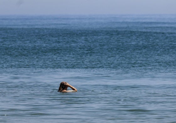 Un hombre se baña en el mar Mediterráneo en la playa del Saler.