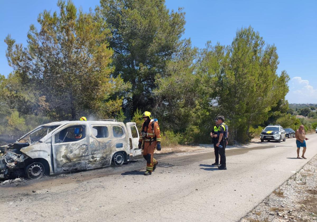 Bomberos y policías locales junto al coche siniestrado.