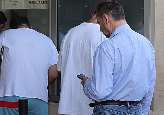 Ábalos mira el móvil mientras espera su turno para firmar en la Ciutat de la Justicia.