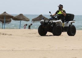 Un policía local vigila en quad la playa de Valencia.