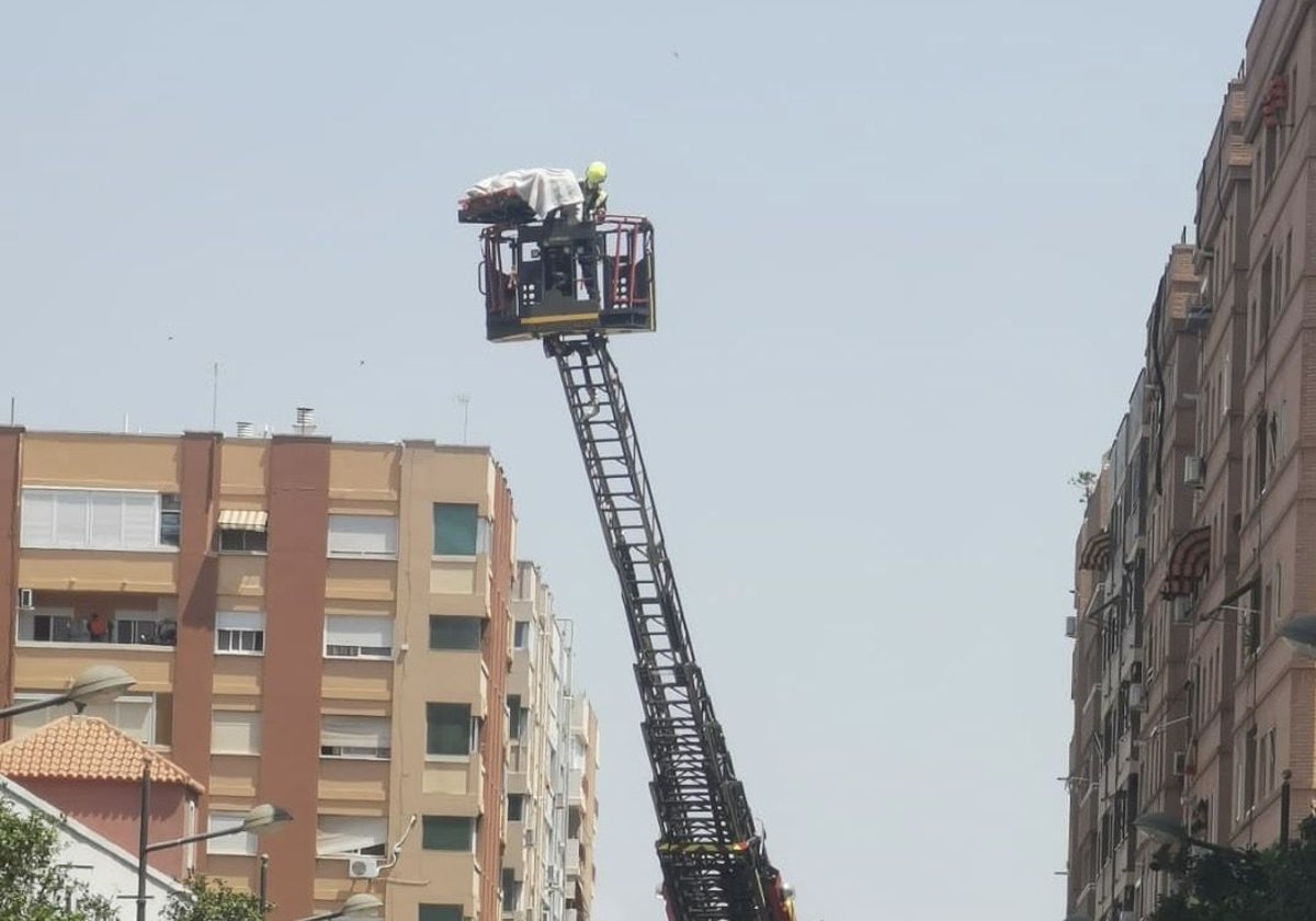 Los bomberos rescatan al hombre por una ventana del séptimo piso.