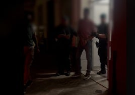 Dos guardias civiles trasladan al detenido.