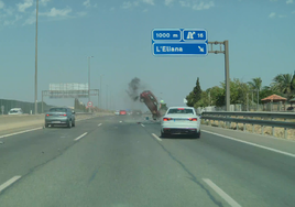 El coche accidentado con las ruedas traseras en el aire tras chocar contra la mediana.