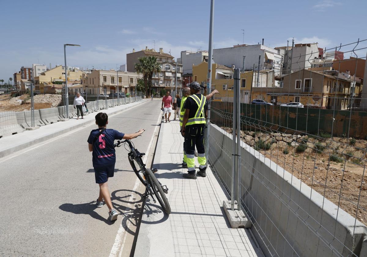 Viandantes en un puente en reconstrucción en Paiporta.