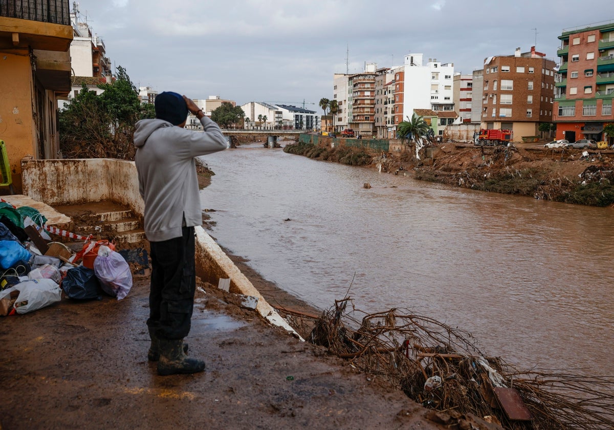 Un hombre observa el barranco del Poyo a su paso por Paiporta.