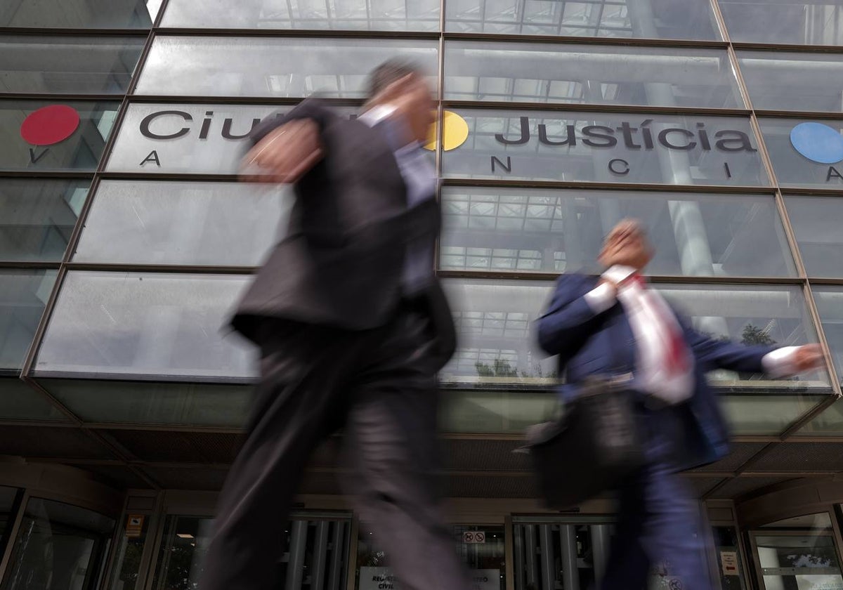 Dos abogados, en la puerta principal de la Ciudad de la Justicia.