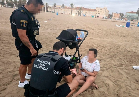 Dos policías locales prestan auxilio a la mujer poco antes de detenerla por no cuidar a su bebé.