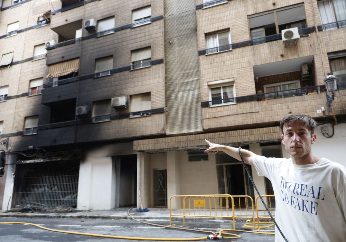 Un vecino muestra el edificio manchado por el humo.