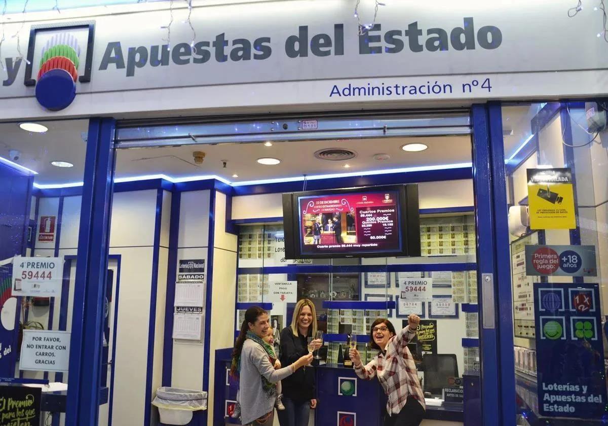 Varias personas esperan en una administración de Loterías y Apuestas del Estado.