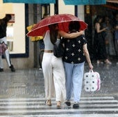 Dos mujeres pasean por la calle en Valencia, hoy.