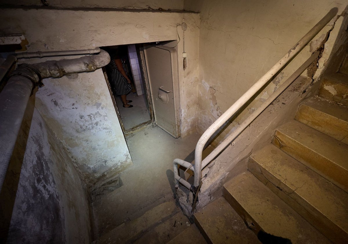 Imagen principal - Escalera de acceso al refugio y estantes para guardar víveres.
