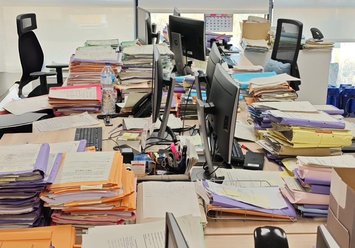Una mesa en un juzgado atiborrada de expedientes.