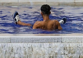 Un joven se refresca debido a las altas temperaturas de este domingo en la ciudad.