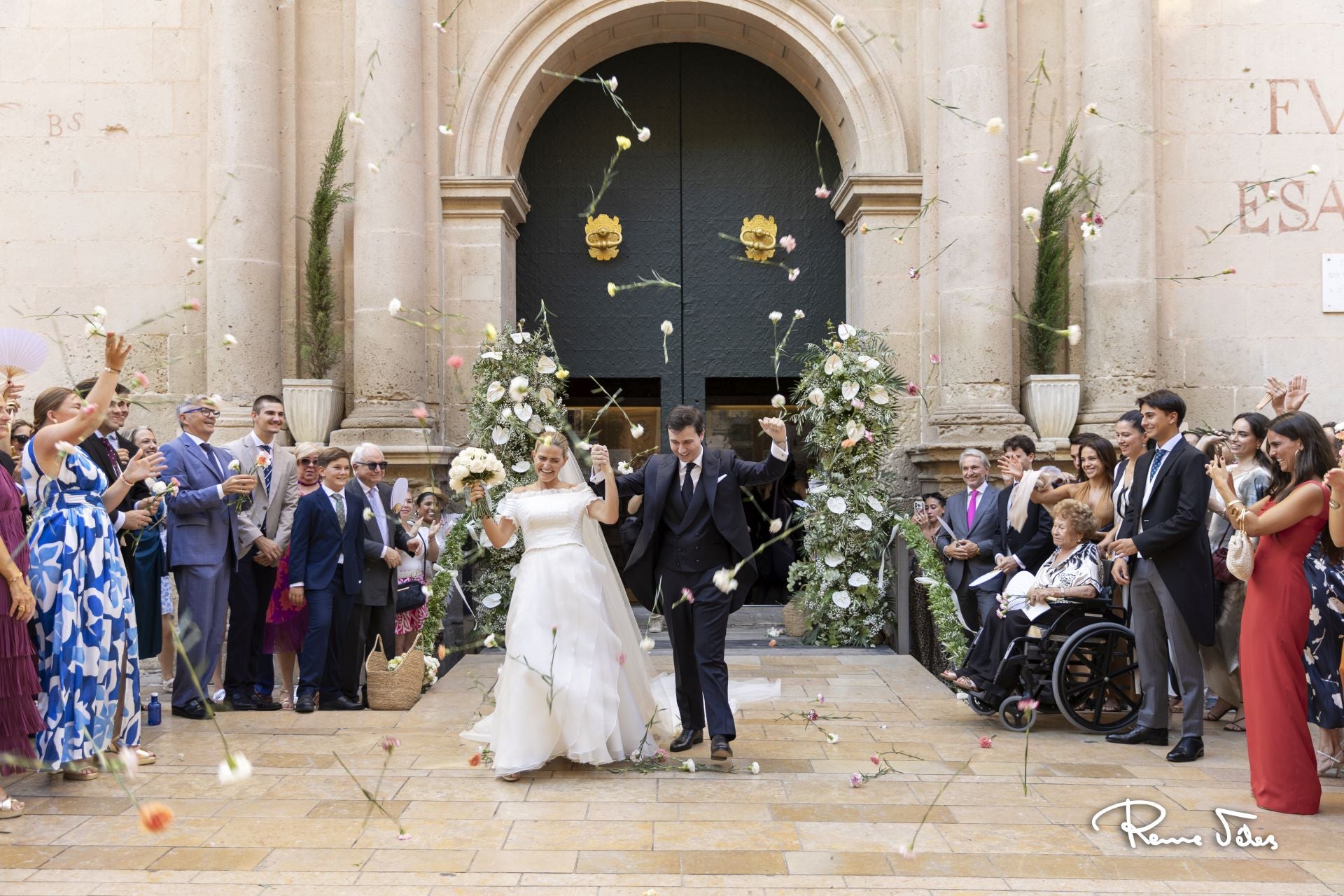 Los novios, Alberto y Paula, recibidos con una lluvia de claveles al salir de la Catedral de Alicante, donde se ofició la ceremonia religiosa.