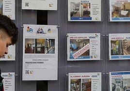 Un joven pasa por delante de una inmobiliaria, en una imagen de archivo.