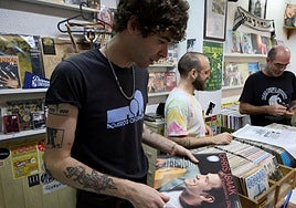 Mario Ballester, vendedor de la mítica tienda 'Oldies' de Valencia, muestra discos demandados por clientela joven.