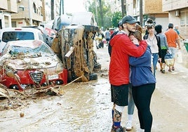 Dos afectados se abrazan tras la dana en Paiporta.
