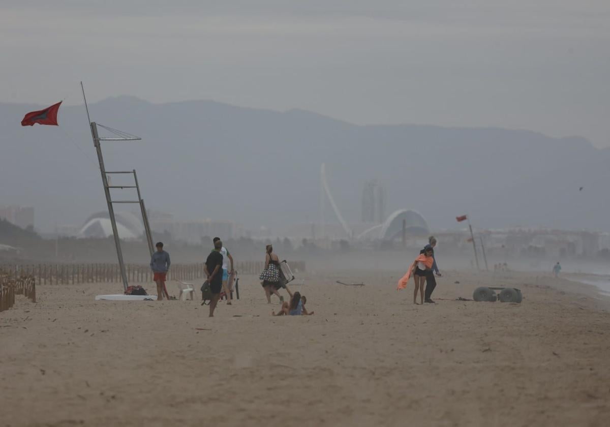 Tres jóvenes se resguardan de la lluvia.