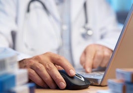Un médico consulta su ordenador.