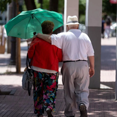 Dos pensionistas pasean por la calle.