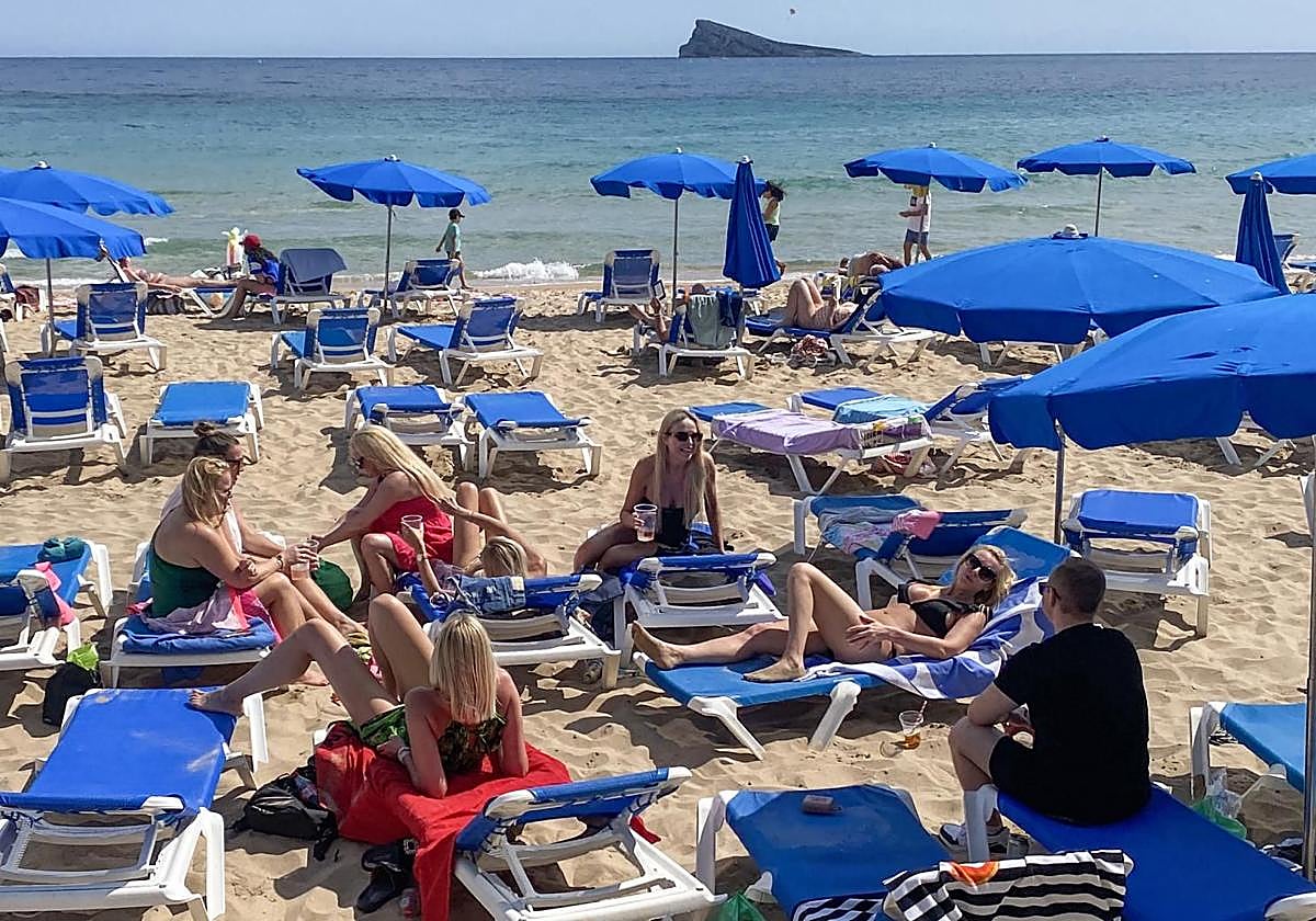 Varias personas disfrutando en la playa de Benidorm.