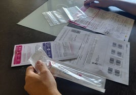 Una destinataria del autotest vaginal revisa el material e instrucciones que Sanidad le ha mandado por correo.