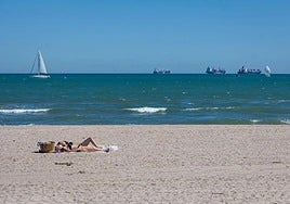 Dos mujeres toman el sol en la playa.