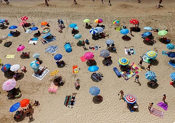 Decenas de turistas disfrutan del sol y la playa en Benidorm.