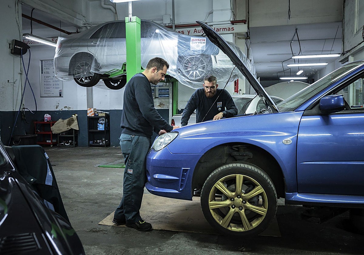 Dos trabajadores en un taller mecánico.