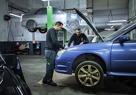 Dos trabajadores en un taller mecánico.