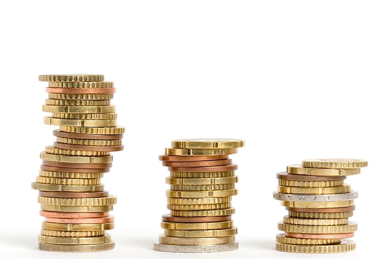 Tres montones de monedas colocados en escala